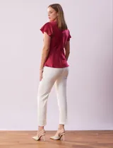 Blusa plateada de satén con manga corta amplia, corte bajo el busto y abertura con botón en la espalda.