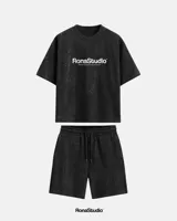 Conjunto deportivo negro con efecto lavado a la piedra, compuesto por una remera de manga corta con logo estampado en el pecho y un short con cordón ajustable en la cintura.