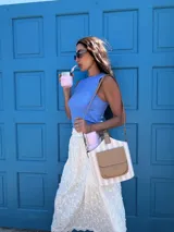 Matero con forma de balde, confeccionado en material símil cuero beige con estampado de rayas verticales en verde militar. Posee bolsillo frontal, asa de mano y correa larga desmontable.