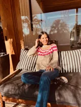 Sweater marrón tejido a mano en mohair con cuello redondo y diseño con motivos geométricos en colores blanco, rosa y celeste.