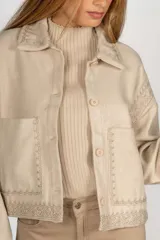Sobrecamisa color beige con bordados en cuello, solapa, mangas y ruedo.