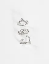 Set de tres anillos plateados de zinc, uno tipo ear cuff con forma ondulada, otro con eslabones y otro con forma orgánica.