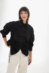 Camisa negra de corte contemporáneo, con ajuste lateral y manga larga, perfecta para destacar en cualquier ocasión.