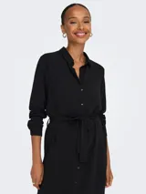 Vestido camisero midi negro con cuello clásico, mangas largas con puños abotonados, cierre frontal con botones y cinturón en la cintura.