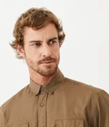 Camisa verde militar de manga larga en sarga de algodón, con cuello clásico, cierre frontal abotonado y dos bolsillos con solapa abotonada en el pecho.