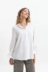 Camisa azul de manga larga con cuello mao y corte holgado.