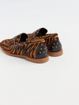 Mocasines con estampado animal print de tigre, confeccionados en cuero.