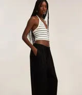 Pantalón femenino de corte fluido, color beige claro, con cintura elástica ajustable mediante un lazo.