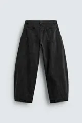 Pantalón de jean celeste con efecto lavado, corte amplio tipo balloon fit, tiro medio, cinco bolsillos y cierre frontal con cremallera y botón.