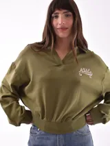 Buzo deportivo color verde oliva con cuello polo y puños ajustados.