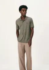 Polo de hombre color gris oscuro jaspeado, con cuello y puños de manga con ribete negro. Presenta un pequeño logo bordado en el pecho.