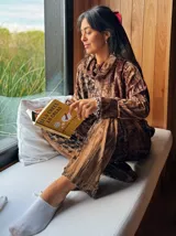 Conjunto de terciopelo color marrón con estampado abstracto, compuesto por una blusa de cuello alto y un pantalón palazzo.