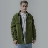 Campera negra de pana con cuello camisero, cierre frontal con botones a presión, dos bolsillos de parche en el pecho y corte recto.