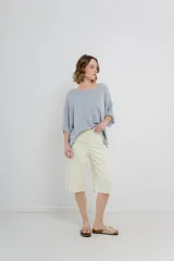 Bermuda de tiro medio color crema, con corte recto y largo a la rodilla. Diseño amplio tipo culotte corto, con dobladillo ancho en el ruedo. Presenta bolsillos delanteros y traseros funcionales.