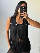 Chaleco negro de símil gamuza con flecos y tachas plateadas.