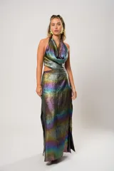 Vestido largo de fiesta con escote halter y espalda descubierta. El tejido iridiscente cambia de color según la luz, creando un efecto camaleónico.