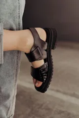 Sandalias negras de cuero con doble tira de velcro y suela chunky.