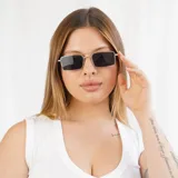 Lentes de sol rectangulares con marco dorado y lentes negros.