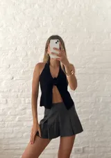 Top negro con escote halter y abertura frontal con detalle de rosa.
