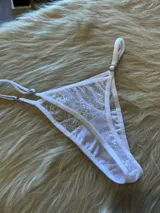 Microtanga blanca de encaje con tiras finas ajustables.