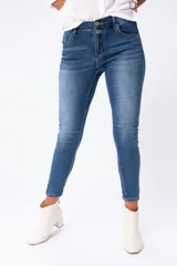Pantalón de jean azul de corte chupín, con cintura alta y dos botones.
