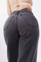 Pantalón de jean negro de corte wide leg con estampa de pequeñas estrellas blancas.