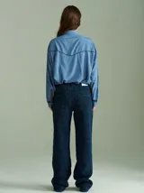 Camisa celeste de algodón con corte clásico y caída suelta. Presenta vivos en cuadrillé trazados en puños, canesú de la espalda y al pie del cuello.