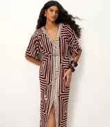 Vestido largo de viscosa con estampado geométrico en tonos bordó y blanco, escote en V y mangas cortas. Incluye un cinturón de cuerda para ajustar la cintura y una abertura frontal.