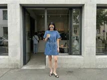 Vestido corto de jean azul con corte recto, mangas cortas y cuello redondo. Incluye cinturón plateado de cadena.