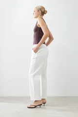 Pantalón wide leg color crudo con pinzas delanteras y cierre con botón y cremallera.