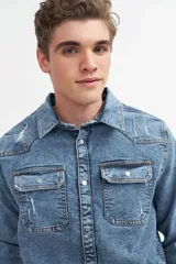 Sobrecamisa de denim negro con detalles desgastados, de corte slim y bolsillos frontales.