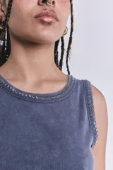Musculosa gris con efecto lavado, corte ajustado y tachas plateadas en cuello y sisas.