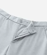 Pantalón de vestir gris con textura, corte slim, con trabillas en la cintura y cierre por botón y cremallera.