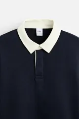 Sudadera tipo polo con cuello clásico, manga larga y diseño a rayas horizontales en color verde oscuro y crudo.