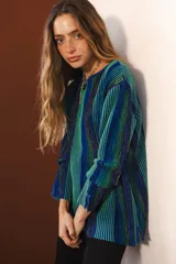 Buzo tejido con lurex, con rayas verticales en tonos naranja, rojo y marrón.