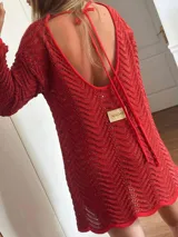 Vestido corto tejido en punto pavo real color rojo con lurex dorado, de manga larga y escote en la espalda con tiras finas.