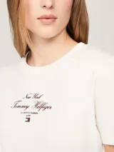 Remera blanca de algodón con cuello redondo y corte regular. Estampado frontal con el logo de Tommy Hilfiger en color rojo.