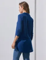 Camisola blanca de manga tres cuartos, marca Rio & Rian. Cuello con solapa y abertura central con botones. Manga con detalle fruncido.