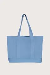 Bolso tipo tote grande color celeste con textura acanalada y asas de hombro.