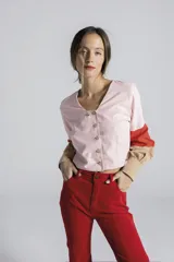 Blusa celeste de escote en V, con botonadura frontal cruzada y mangas largas abullonadas con puños ajustados.
