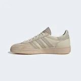 Championes Adidas Handball Spezial color beige con detalles en gris y suela de goma color caramelo. Presentan las tres tiras características de la marca en los laterales y la inscripción "Spezial" en letras doradas.