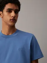 Remera de algodón regenerativo, color azul, con corte regular, cuello redondo y mangas cortas, adornada con un monograma bordado de Calvin Klein en el pecho.