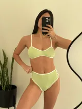 Conjunto de bikini verde claro con ribetes blancos, compuesto por un corpiño tipo top con breteles finos y una bombacha de tiro alto.