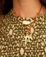 Collar con dije de bronce macizo con forma orgánica o de coral, suspendido de un hilo de seda natural color naranja.