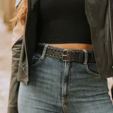 Cinto de cuero negro con trenzado artesanal, hebilla metálica plateada y doble pasador desmontable.