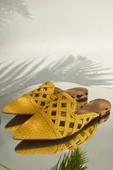 Mules color amarillo mostaza, con punta fina y capellada tejida.