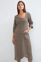 Vestido midi color crema con escote cuadrado, manga francesa con tajo y bolsillo lateral. Confeccionado en lana fina sin teñir.