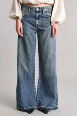 Pantalón de jean de tiro medio, corte wide leg extra largo, color azul medio.