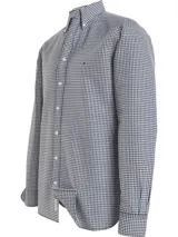 Camisa Tommy Hilfiger de corte regular, confeccionada en algodón orgánico Oxford con diseño de cuadros Vichy. Presenta cuello con botones, puños redondeados con dos botones y logo de Tommy Hilfiger bordado en el pecho.