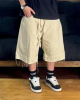 Bermuda de corte baggy color beige crema, con costura vertical trasera en cada pierna y detalle artesanal visible en el bajo. Incluye un cordón extra confeccionado en la misma tela.